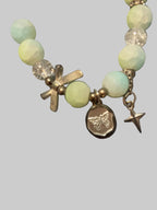 A bow and a butterfly charmed green bracelet